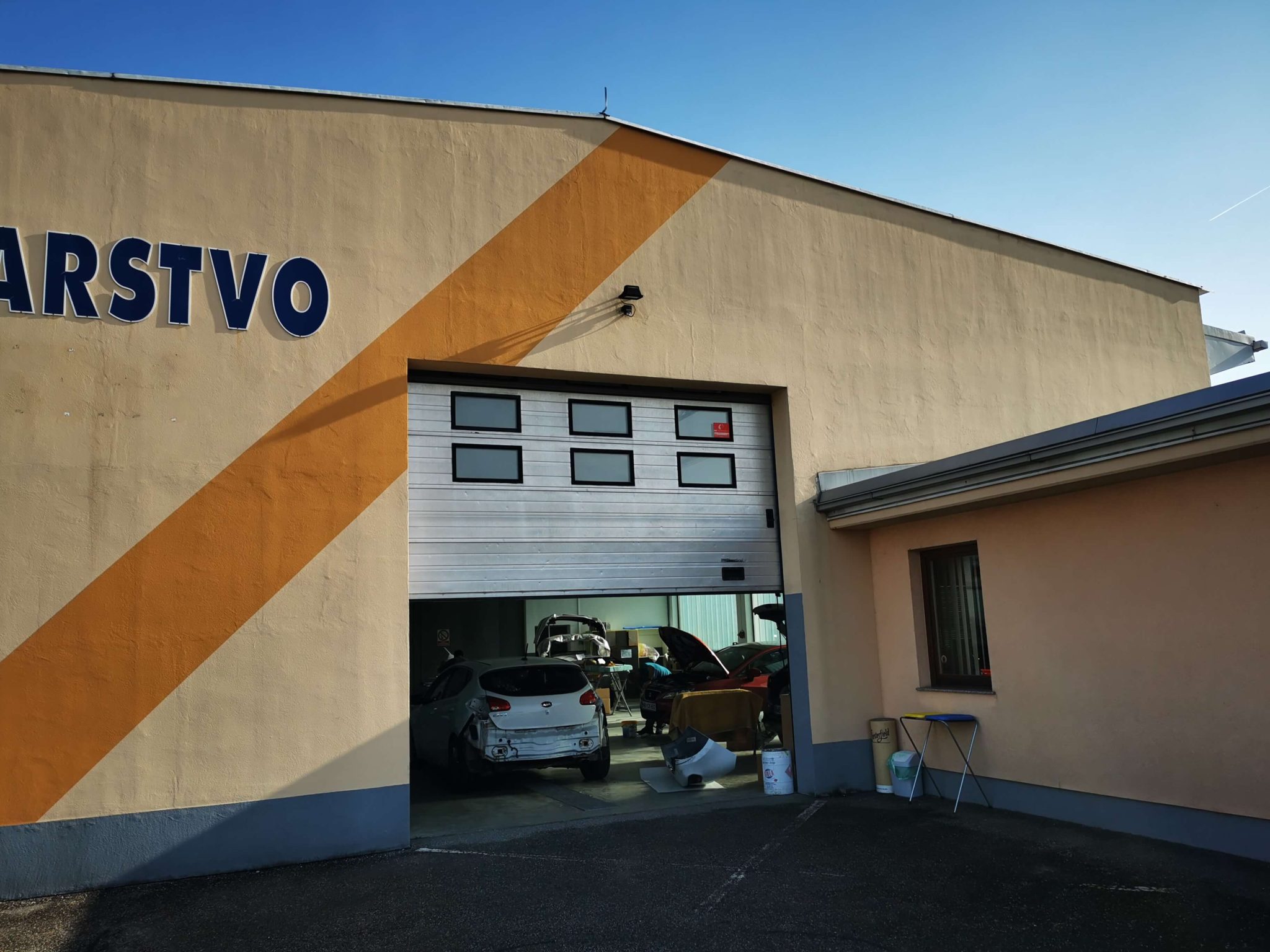 Zastarana fasada avtoličarstva na Teznu v Mariboru, ki je potrebna pleskanja fasade.
